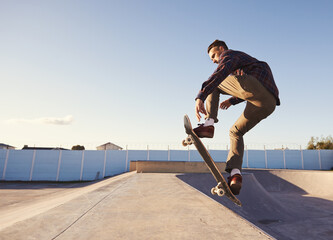 A rad day at the skate park. A young man doing tricks on his skateboard at the skate park. - obrazy, fototapety, plakaty