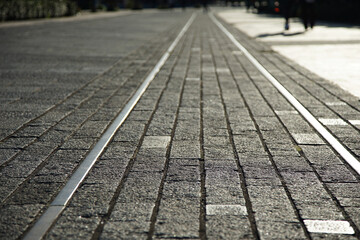Cobblestone streets and streetcar rails lit up by the setting sun