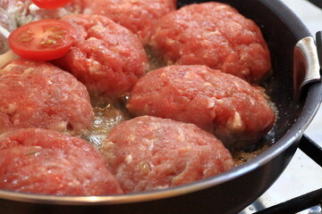 Cooking chops in a frying pan.