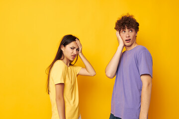 young boy and girl casual clothes posing emotions antics yellow background unaltered