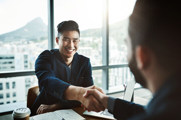 Its safe to say he made a great impression. Shot of two young businessmen shaking hands while...