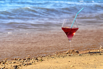 Wine glass with a cocktail by the sea.