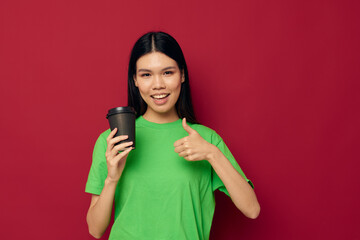 woman with Asian appearance in a green t-shirt a glass of drink fun isolated background unaltered