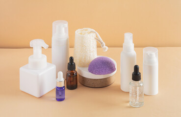 Facial cosmetic products and konjac sponge on a beige background