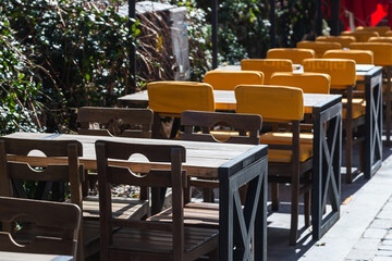 Atmospheric summer photography. Wooden cafe chairs  and  tables. Outdoor street cafe