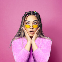 Surprised young pretty woman on colorful pink background portrait