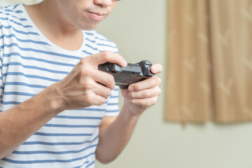 Close up hands of man, gamer using gaming controller or game pad when play video console game or online computer game at home.Gaming is relaxing from stressed and making friend, creativity, knowledge. © Thitiwat
