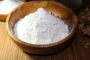 Fototapeta na wymiar Potato starch in a wooden bowl. Starch is poured in a slide