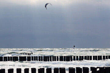 Kite surfer trick jumping behind the groins of Ahrenshoop coast, Baltic Seacoast, during summer storm