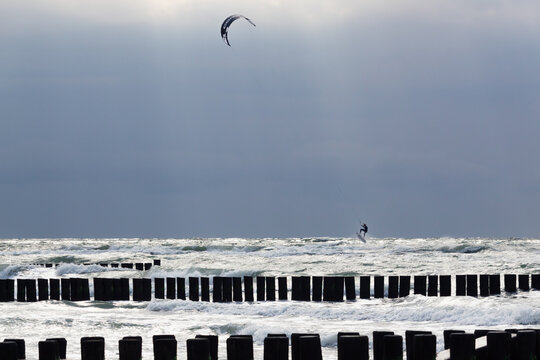 Kite surfer trick jumping behind the groins of Ahrenshoop coast, Baltic Seacoast, during summer storm