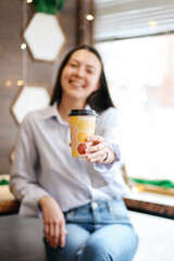 smiling brunette girl in a cafe drinking coffee