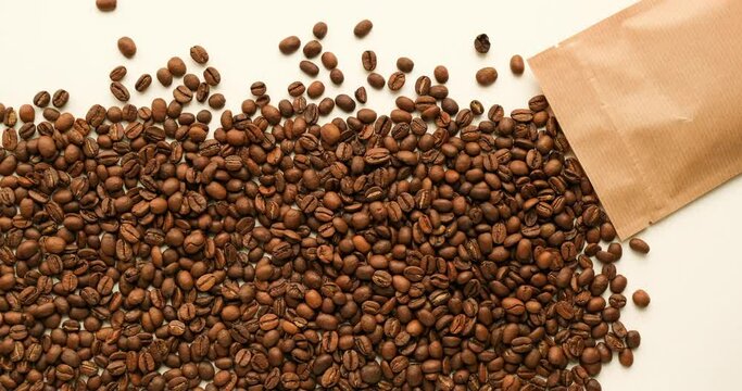 Coffee beans spill out of a paper zip bag and fill the entire background. 4K stop motion animation