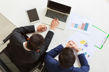 Top view studio shot of unrecognizable unknown mentor male professional successful businessman in formal suit holding hand hugging shoulder teaching new employee analyzing report at working desk