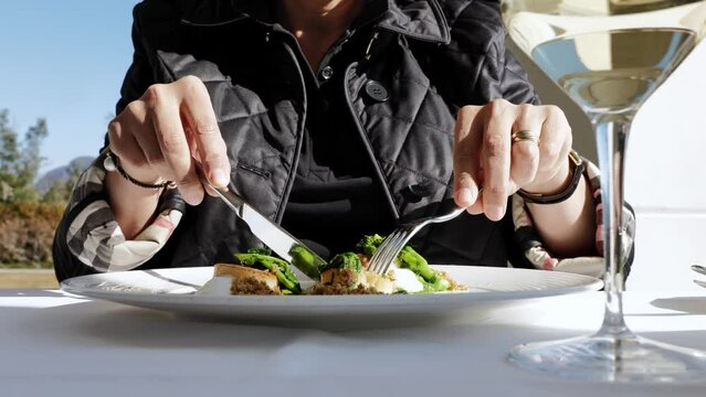 Woman Eating in a Luxury Restaurant Seared scallops with Turnip Greens and Buffalo Stracciatella Cheese and Aromatic Bread in a Sunny Day in Switzerland.