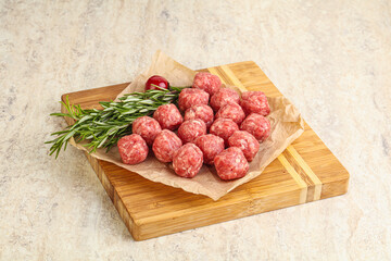 Raw uncooked beef meatballs served rosemary