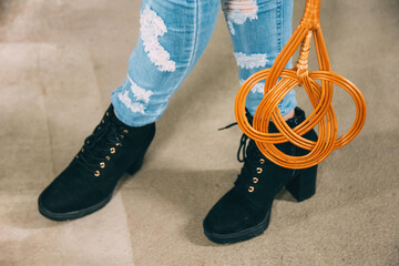a carpet beater in front of woman legs
