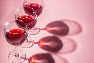 Glasses of red wine on a pink background. Alcoholic drink.