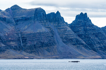 Fjord, road and huge colorful mountains, long shot