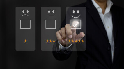 Businessman touching the virtual screen on the happy Smiley face icon in service. Customer service and Satisfaction concept.