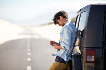 I need a little help out here. A young man phoning for roadside assistance. © Marine G/peopleimages.com