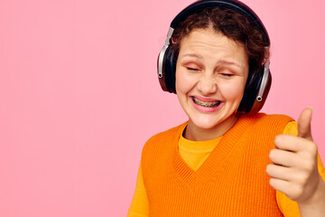 pretty girl in an orange sweater headphones music entertainment cropped view unaltered