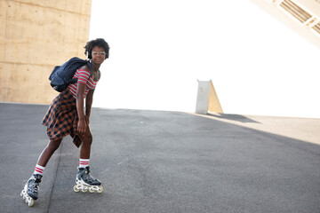 Beautiful woman with roller skates. Urban happy girl with curly hair enjoy in sunny day.