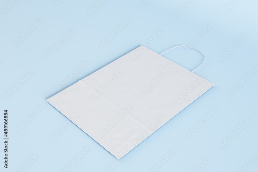 Wall mural close up of empty white paper bag on blue backdrop. shopping concept. mock up, 3d rendering.