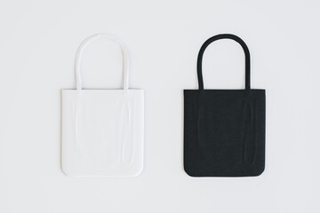 View from top on eco shopping concept with white and black natural fabric bags on light surface. 3D rendering, mockup