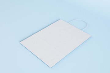 Close up of empty white paper bag on blue backdrop. Shopping concept. Mock up, 3D Rendering.