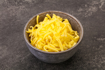 Shredded yellow cheese in the bowl