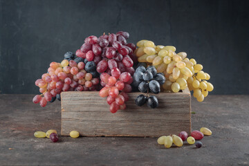 Grapes in a wooden box on a dark background