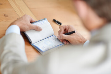 He always pays on time. Cropped closeup shot of a businessman signing cheques.