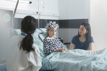Clinic pediatric medic analyzing EEG scan results of sick little child while in pediatric ward...