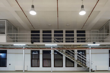 Interior of a large industrial space with mezzanine at night - obrazy, fototapety, plakaty
