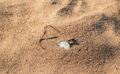 Sands of time, Antique rotten pocket watch buried partial in the sand. - Powered by Adobe
