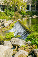 Fototapeta na wymiar Waters of the Sorgue river streaming in the village of Fontaine de Vaucluse in Provence, France