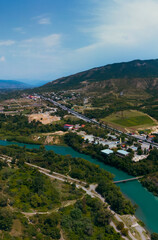Fototapeta na wymiar A place where two rivers of different colors meet. Aerial view panorama. Mountains. Travel and vacation concept. Summer day. Tsitsamuri in Georgia. Vertical photo