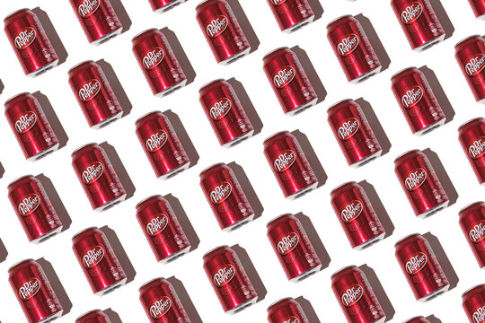 Dr. Pepper cans pattern with hard shadow on white background.