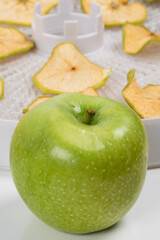 green fresh apple on the background of dried fruit slices