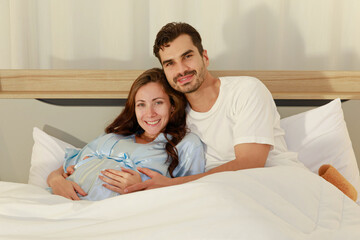 Cheerful pregnant wife smile and happy as beloved husband give love by warm hug on belly of unborn baby and adore her maternity