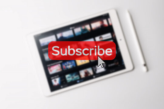 Subscription plan. Red online video subscribe button. Internet service on laptop digital tablet blured technology background. Visual contents concept. Social networking service.