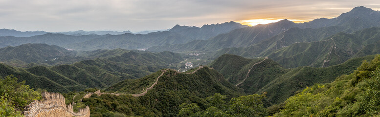 Ein Bergpanorama an der chinesischen Mauer: die ersten Lichtstrahlen der aufgehenden Morgensonne...