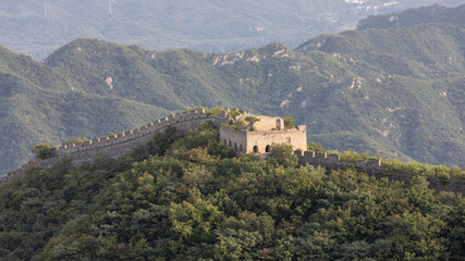 Ein ockerfarbener Wachturm der chinesischen Mauer am Mauerabschnitt Jiankou auf einem Bergkamm,...
