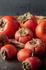 Different persimmons on a dark background