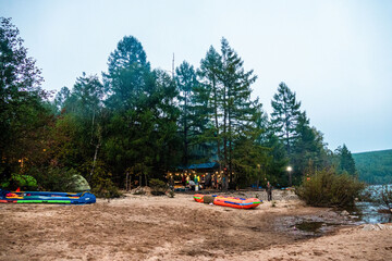 tourists in a forest camp on the river bank against the background of the forest