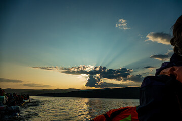 sunset on the background of mountains the rays of the sun break through the beautiful clouds