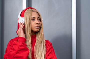 Una joven mujer afroamericana vestida con ropa deportiva y unos auriculares inalámbricos