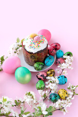 Obraz na płótnie Canvas Easter cake (kulich), colorful eggs, spring flowers on abstract pink background. Easter holiday. festive spring season.
