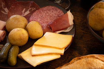 charcuterie plate with potatoes and wine on wooden table