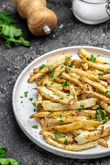 Oven roasted parsnips side dish on plate. Delicious vegetarian breakfast or snack, Clean eating, dieting, vegan food concept. vertical image. top view. place for text,